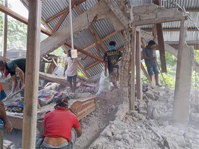 Menschen räumen die Trümmer eines durch ein Erdbeben beschädigten Hauses in Ost-Manggarai in der Provinz Ost-Nusa Tenggara weg