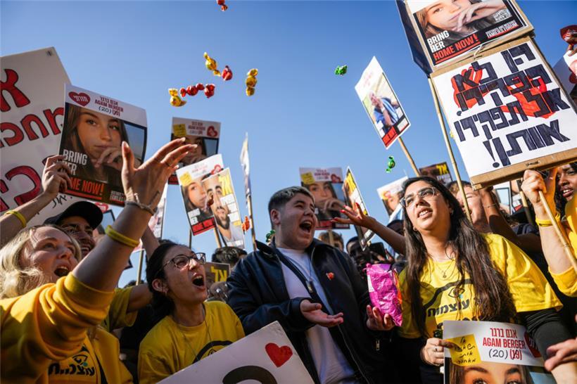 Menschen reagieren auf die Übertragung der Freilassung der israelischen Soldatin Agam Berger, eine von acht Geiseln, die am Donnerstag im Rahmen einer Waffenruhe im Gazastreifen freigelassen werden sollen

