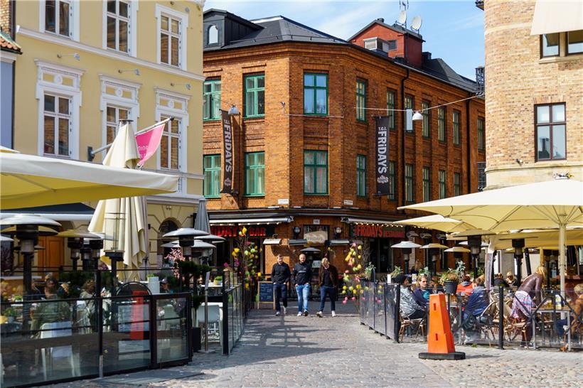 Menschen sitzen in der Sonne in Restaurants und Cafés an dem Platz Lilla Torg. In Schweden waren bis Freitag, den 17. April 2020, 1.400 Menschen an der Virusinfektion gestorben – sehr viel mehr als in den anderen nordischen Ländern.
