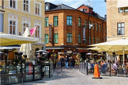 Menschen sitzen in der Sonne in Restaurants und Cafés an dem Platz Lilla Torg. In Schweden waren bis Freitag, den 17. April 2020, 1.400 Menschen an der Virusinfektion gestorben – sehr viel mehr als in den anderen nordischen Ländern.
