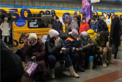 Menschen sitzen in einer U-Bahn-Station, die während eines Raketenangriffs als Luftschutzbunker genutzt wird
