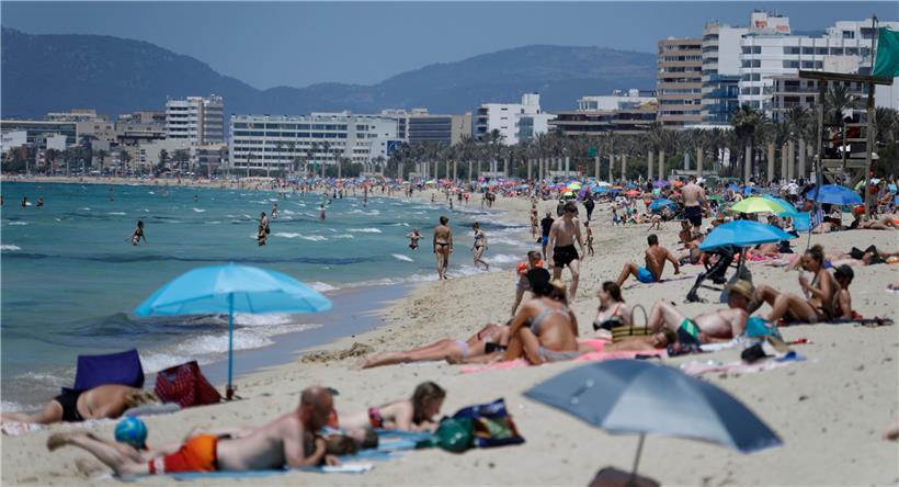 Menschen sonnen sich am Strand von Arenal: Die Tourismusbranche sieht ihr Sommergeschäft bedroht
