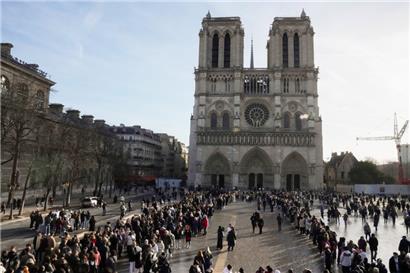 Menschen stehen Schlange, um die Kathedrale Notre-Dame in Paris zu betreten
