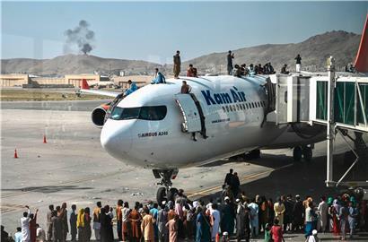 Menschen steigen am Flughafen in Kabul auf das Dach eines Flugzeugs

