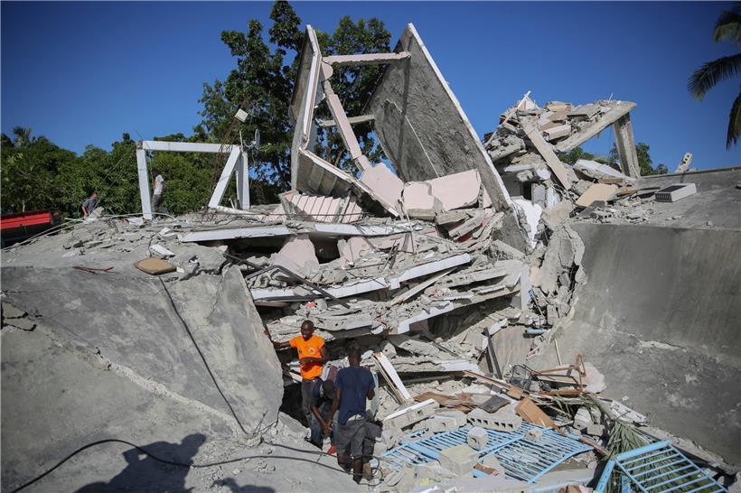 Menschen suchen nach Überlebenden in einem vom Erdbeben zerstörten Haus in Les Cayes, Haiti. 
