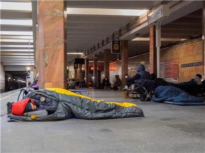 Menschen flüchten während russischem Luftangriff und suchen Schutz in einer belebten U-Bahn-Station.