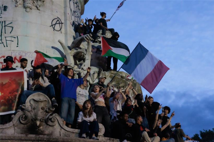 Menschen versammeln sich nach der zweiten Runde der Parlamentswahlen zum Feiern an der Statue auf dem Platz der Republik in Paris

