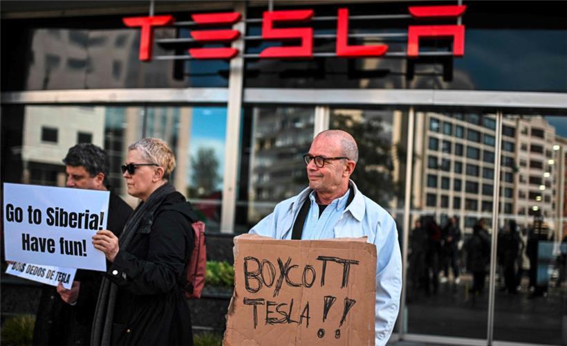 Menschen versammeln sich vor einem Tesla-Händler in Lissabon, um gegen den CEO von Tesla und SpaceX, Elon Musk, zu protestieren
