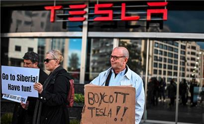 Menschen versammeln sich vor einem Tesla-Händler in Lissabon, um gegen den CEO von Tesla und SpaceX, Elon Musk, zu protestieren
