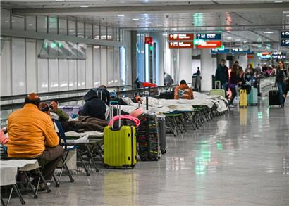 Menschen warten nach Drohnensichtungen und Flugausfällen in Flughafen München auf Feldbetten. Wegen Drohnensichtungen sind am Donnerstagabend rund 20 Flüge ausgefallen.

