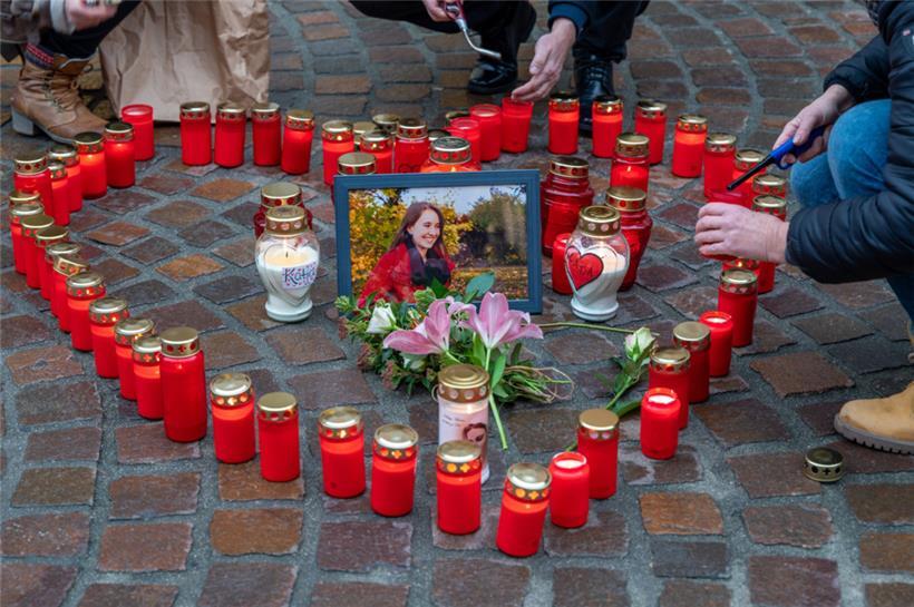 Menschen zünden Kerzen an der Stelle an