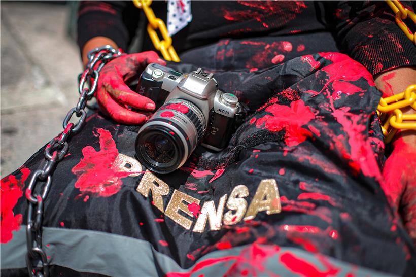 Mexiko, Mexiko-Stadt: Die Journalistin und Aktivistin Arango hält eine rot verschmierte Kamera und eine Presseweste bei einer symbolischen Aktion vor der mexikanischen Staatsanwaltschaft gegen die Ermordung des Journalisten Nevith Condes Jaramillo
