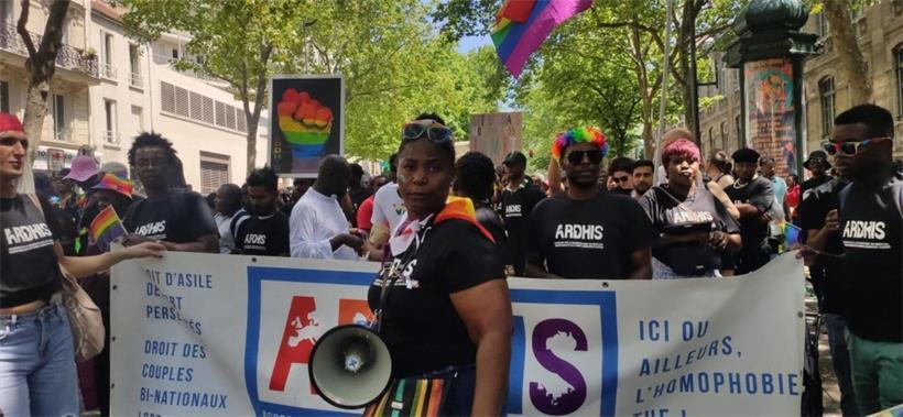 Migranten bei Pride 2023 in Paris mit Ardhis-Banner für Rechte homosexueller und transsexueller Asylbewerber