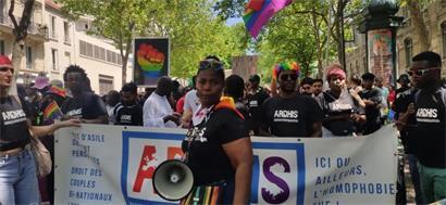 Migranten bei Pride 2023 in Paris mit Ardhis-Banner für Rechte homosexueller und transsexueller Asylbewerber