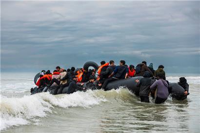 Migranten besteigen das Schlauchboot eines Schmugglers und versuchen, den Ärmelkanal zu überqueren
