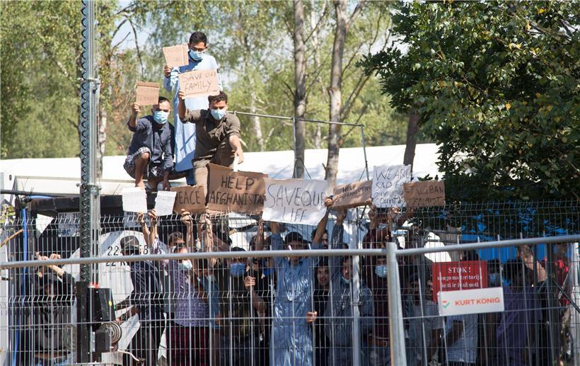 Migranten im Lager in Rudninkai in Litauen zeigen bei einer Kundgebung Plakate mit Aufschriften wie „Help Afghanistan“
