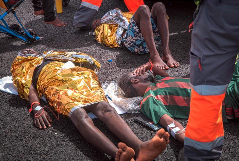 Migranten werden nach der Ankunft eines "Cayuco" (kleines Holzkanu) mit 59 Migranten an Bord im Industriehafen von Granadilla de Abona auf der Kanareninsel Teneriffa am 13. August 2023 medizinisch versorgt.
