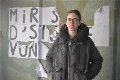 Milena Steinmetzer, eine der Organisatorinnen des Frauenstreiks, vor einer zerrissen feministischen Collage, die einst besagte:  „Mir sinn d’Stëmme vun deenen, déi dir verstommt hutt.“
