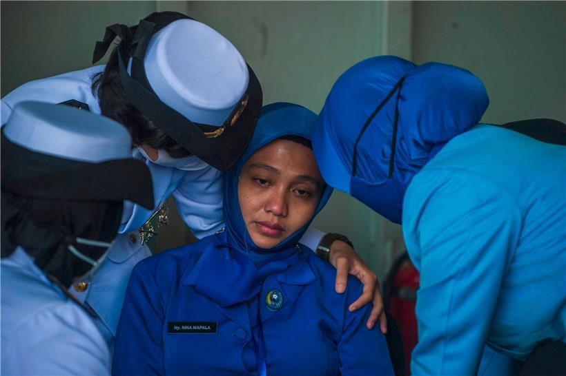 Militärangehörige trösten eine Witwe: Indonesien will wissen, was 53 Crewmitglieder das Leben kostete 
