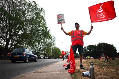 „Millionen spüren die Teuerung“: ein Dockarbeiter mit der Fahne seiner Gewerkschaft
