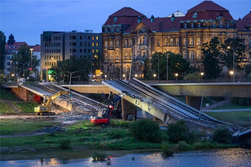 Mit Baggern werden weitere Teile der eingestürzten Carolabrücke abgerissen
