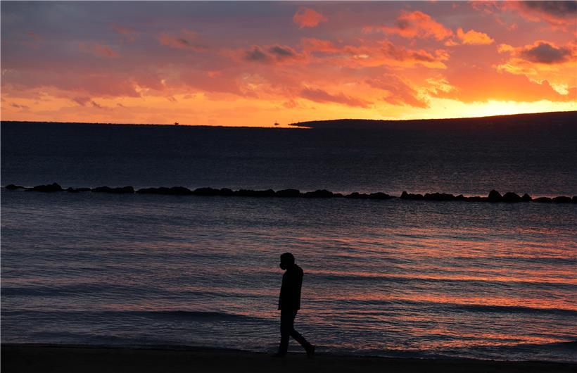 Mit Gesichtsmaske im Sonnenuntergang: Der Tourismus ist Mallorcas wichtigste Einnahmequelle
