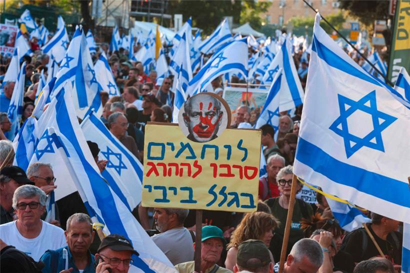 Mit Plakaten und lauten Rufen fordern die Protestierenden Neuwahlen in Israel und ein Ende des Gazakriegs
