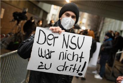 Mit Schildern und Plakaten erinnern Demonstranten am Donnerstag vor dem Landgericht an das Schicksal des ermordeten Kasseler Regierungspräsidenten Lübcke
