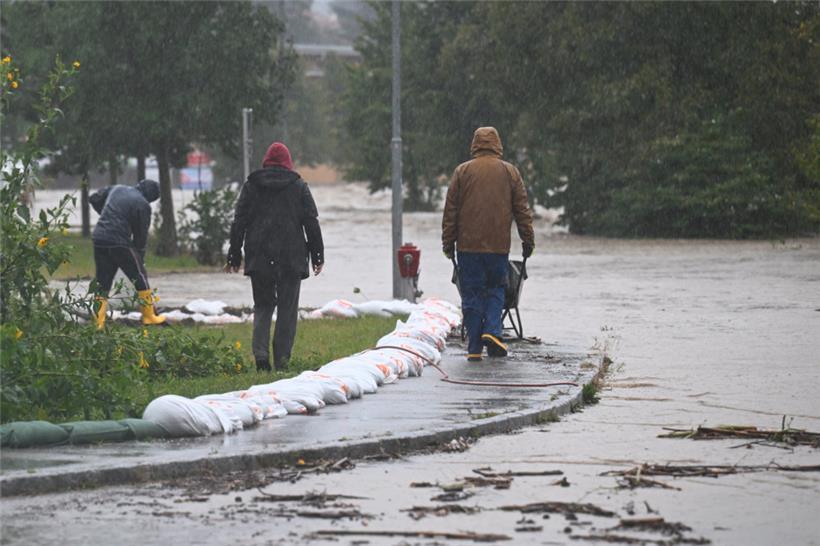 Mit Schubkarren und Sandsäcken versuchen Anwohner in Neulengbach (Österreich) das Hochwasser zu bekämpfen
