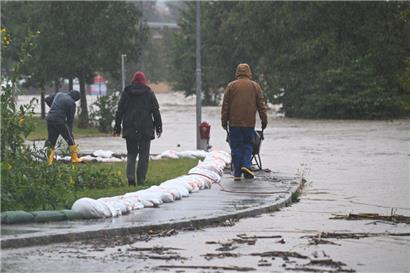 Mit Schubkarren und Sandsäcken versuchen Anwohner in Neulengbach (Österreich) das Hochwasser zu bekämpfen
