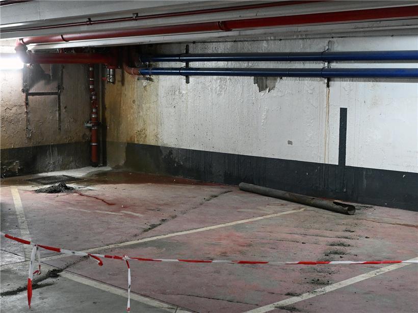 Abgeblätterte Farbe und feuchte Stellen an dunklem Parkhaus unter Theaterplatz in Hauptstadt, sichtbare Bauschäden und Renovierungsbedarf