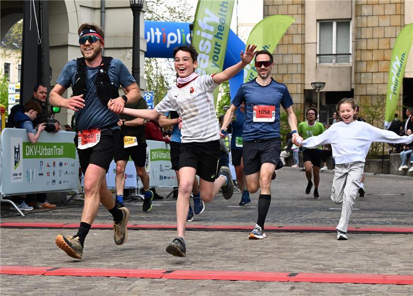 Läufer mit persönlichem Coach überquert gemeinsam die Ziellinie beim Marathonlauf
