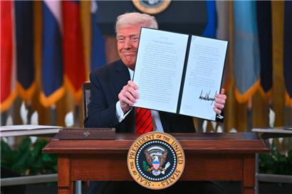 Mit demonstrativer Selbstzufriedenheit präsentiert Donald Trump das unterzeichnete Dekret, mit dem er das US-Bildungsministerium auflöst – Amerikas Kinder sind gerettet …
