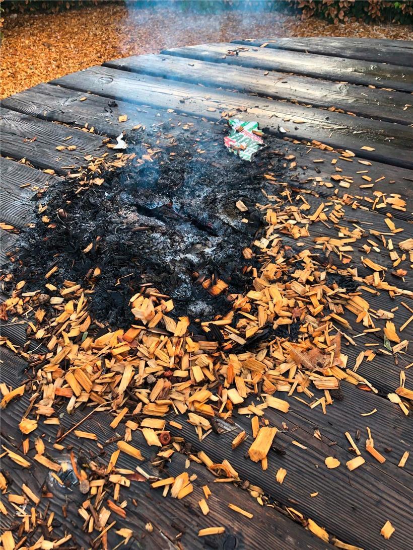 Mit den Hackschnitzeln, die als Fallschutz unter dem Kinderspielplatz liegen, wurde auf einem der Picknicktische im Schulhof ein Feuer entzündet
