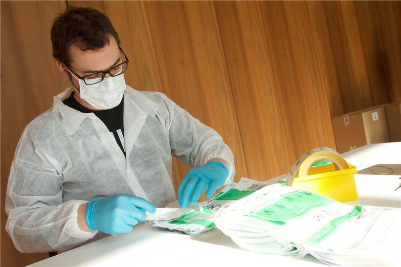 Mitarbeiter des LNS hantieren mit Corona-Testkits