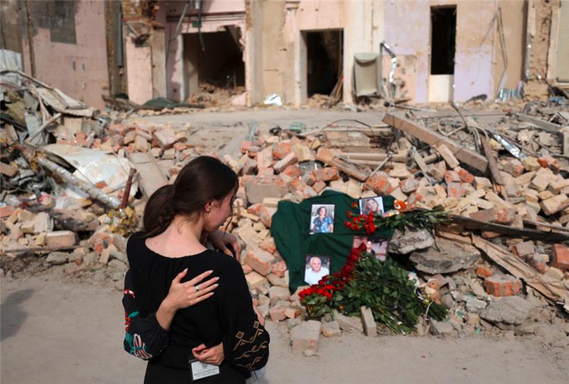 Mitarbeiterinnen eines Kinderkrankenhauses, das jüngst von der russischen Armee angegriffen wurde, trauern während einer Feier um getötete Kolleg*innen
