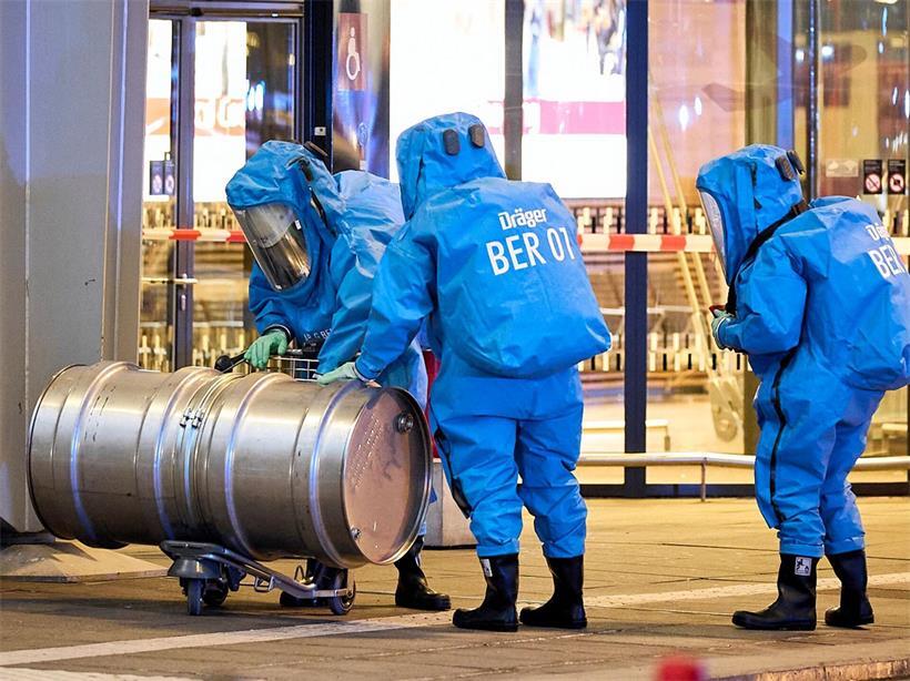 Mitglieder der Feuerwehr in Chemikalienschutzanzügen sind im Einsatz vor dem Terminal 1 am Flughafen BER