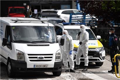 Mitglieder der spanischen Katastrophenschutzeinheit UME in Schutzkleidung stehen vor dem „Palacio de Hielo“ in Madrid, der zum Leichenschauhaus umfunktioniert wurde
