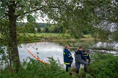Mitglieder des Technischen Hilfswerks errichten auf der Sauer eine Ölsperre.
