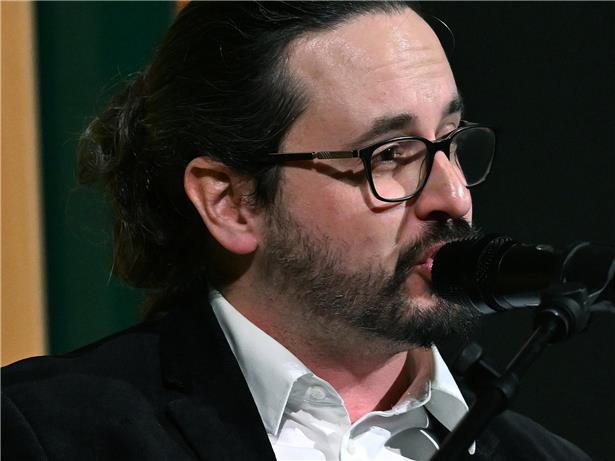 Raoul Migliosi spricht als Moderator und Schauspieler bei einer Veranstaltung vor Publikum