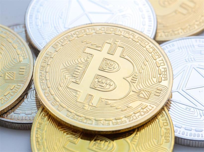 Münzen mit den Symbolen von Bitcoin (M) und Ethereum sind auf einem Tisch angeordnet