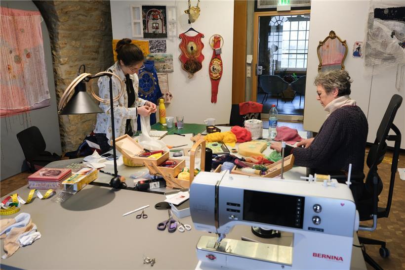 Mutter und Tochter arbeiten gemeinsam an einem kreativen Projekt in hellem, freundlichem Arbeitszimmer