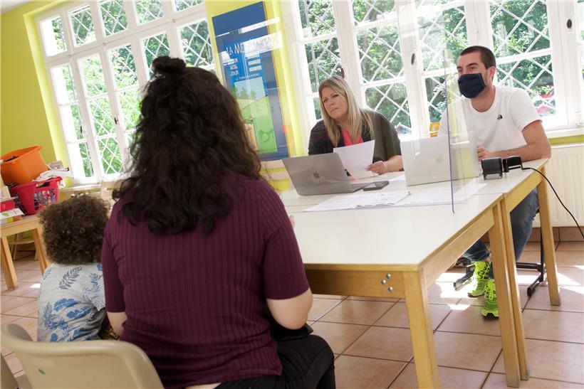 Mutter und Kind ohne Aufenthaltsgenehmigung: Laurence Hever und Praktikant Paolo Zahlen von der ASTI geben Bons für ein „Office social“ aus
