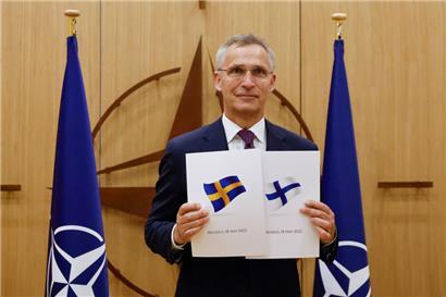 NATO-Generalsekretär Jens Stoltenberg zeigt die Dokumente, während Schweden und Finnland in Brüssel offiziell ihre Anträge auf die NATO-Mitgliedschaft stellen
