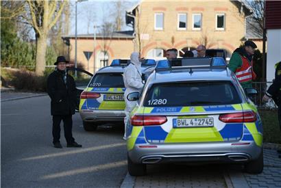  Nach Schüssen in Rot am See im Nordosten Baden-Württembergs stehen Polizeiautos an einem Haus. Hier sollen mehrere Menschen getötet worden sein. 
