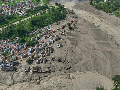 Nach Sturzfluten im nepalesischen Distrikt Nuwakot stehen beschädigte Häuser gefährlich nahe an den angeschwollenen, mit Treibgut verstopften Ufern des Trishuli-Flusses. Eine massive Sturzflut in Nepal hat nach Behördenangaben einigen Menschen das Leben gekostet