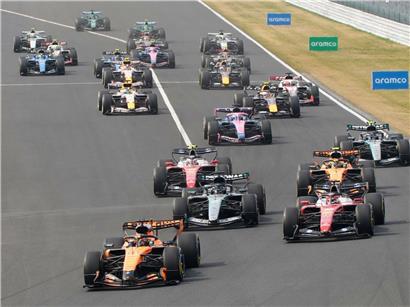 Formel-1-Logo vor Tafel mit skizzierten Rennstrecken und Notizen zu neuen Regeländerungen und Strategien