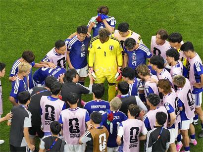 Japanische Fußballspieler versammeln sich nach 22 und 67 Minuten zur Trinkpause während eines Spiels