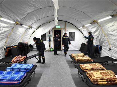 Beheiztes Zelt in Kiew nach russischen Angriffen auf Energieversorgung, Bewohner wärmen sich und übernachten dort