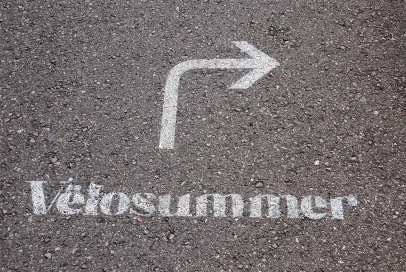 Neben den Pfeilen auf den Schildern ist auch auf dem Asphalt die Vëlosummer-Stre...